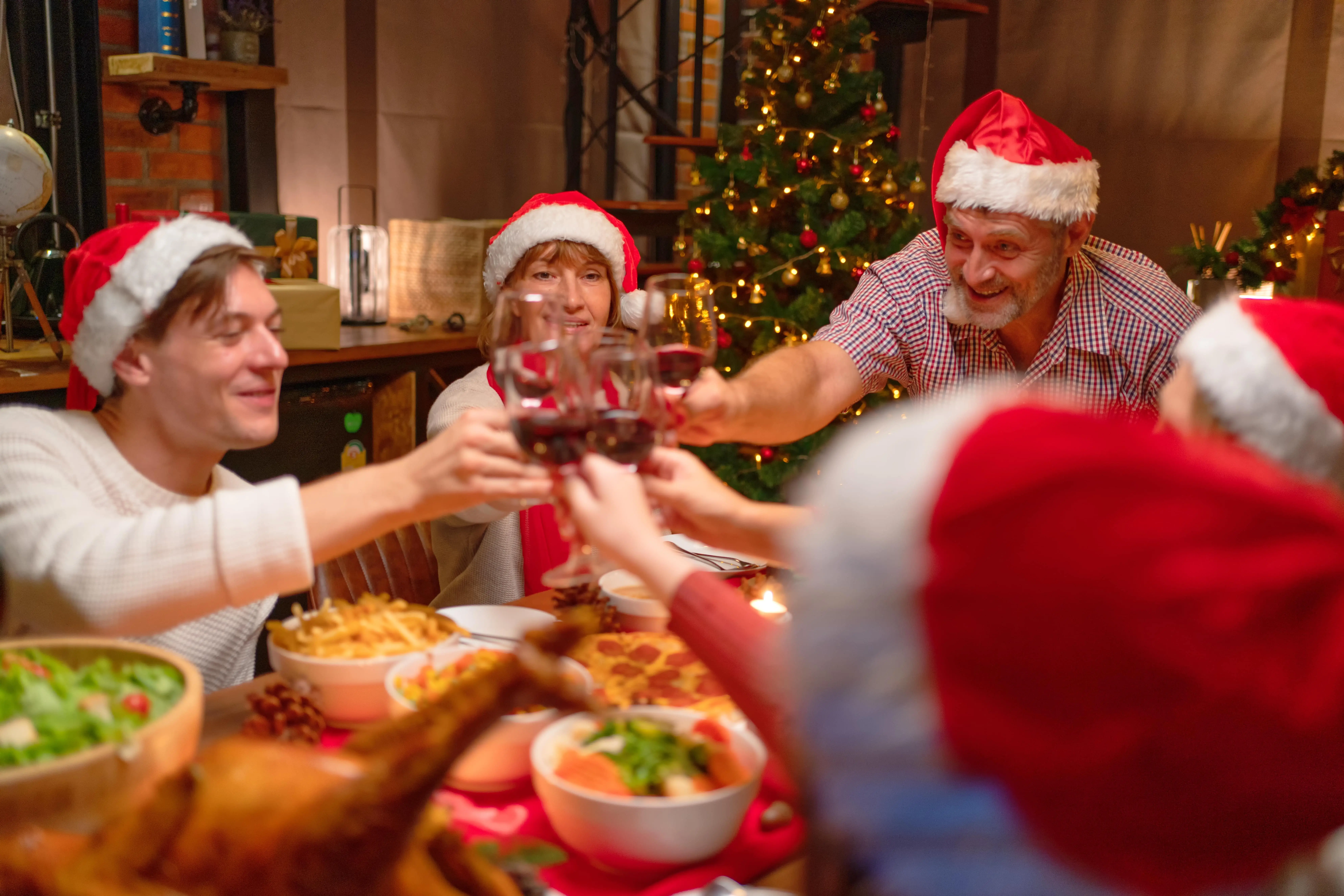 Membrii unei familii care ciocnesc paharele de vin la masa de sarbatori